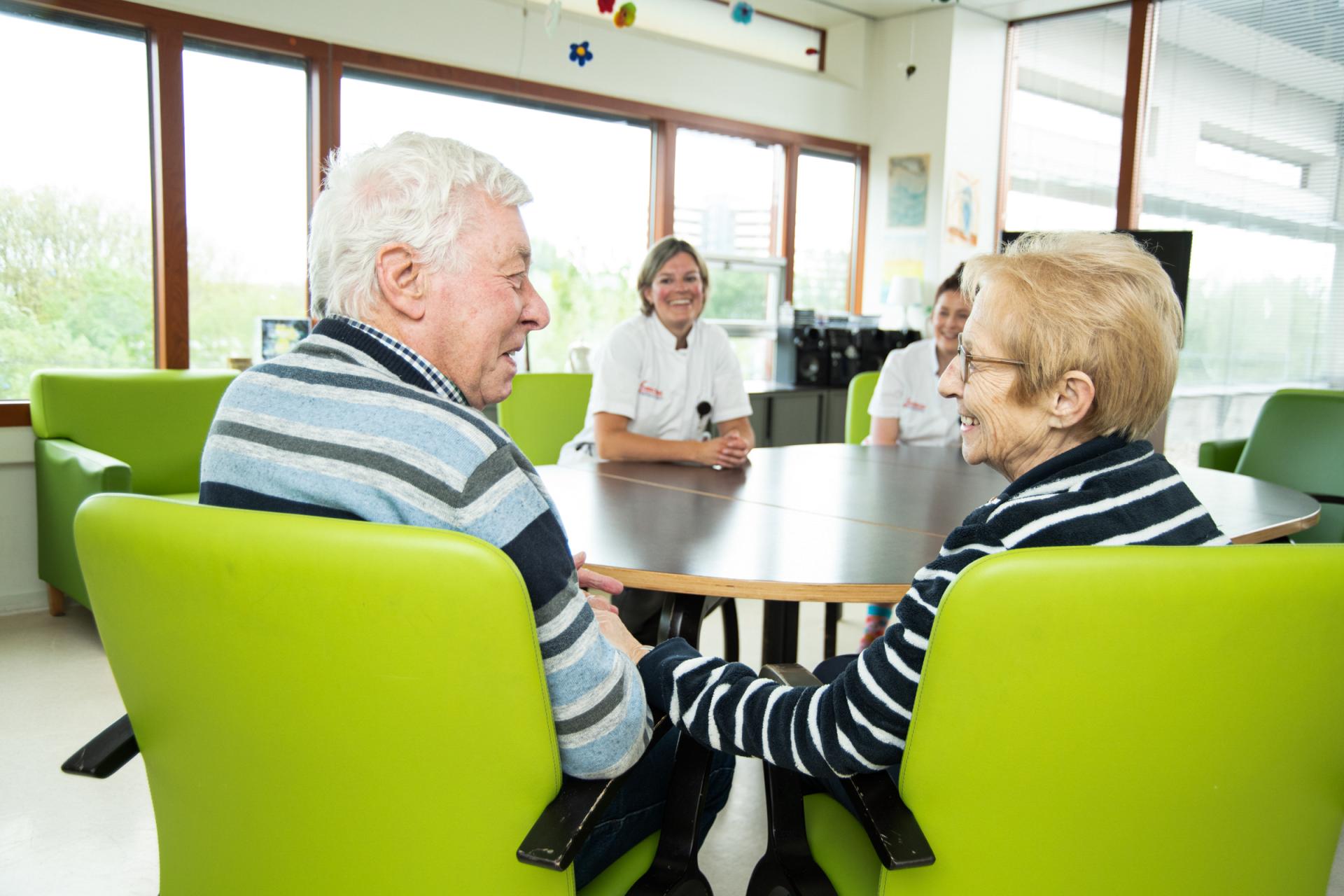 Patient en partner hebben familiegesprek met geriater en verpleegkundige